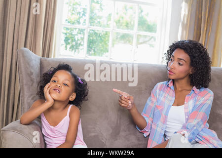 Hübsche Mutter ihre Tochter Schelte auf der Couch zu Hause im Wohnzimmer Stockfoto