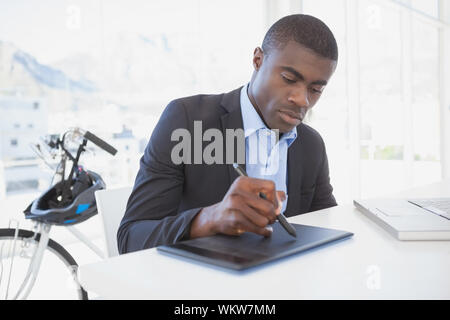 Fokussierte Designer Zeichnung auf dem Digitizer in seinem Büro Stockfoto