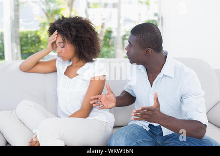 Attraktive Paar in ein Argument auf der Couch zu Hause im Wohnzimmer Stockfoto