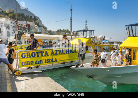 Insel Capri, Italien - AUGUST 2019: Menschen aus einem touristischen Ausflugsboot nach dem Besuch der Blauen Grotte auf der Küstenlinie der Insel Capri Stockfoto