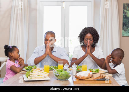 Happy Family sagen Gnade vor der Mahlzeit zu Hause in der Küche Stockfoto