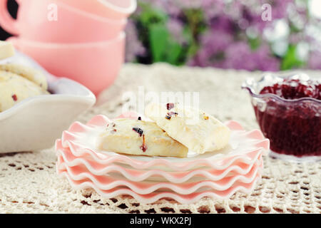 Nahaufnahme des frisch gebackenen Scones cranberry sitzen auf einen freien Tisch mit Erdbeere bewahrt. Selektiver Fokus mit geringer Tiefenschärfe. Stockfoto