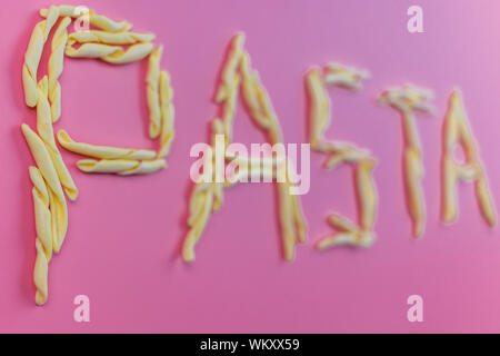 Wort defokussierten Pasta mit italienische Pasta mit rosa Hintergrund gemacht Stockfoto