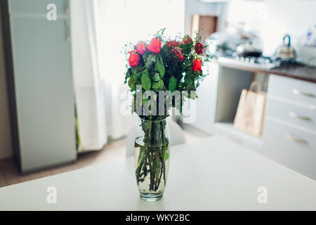 Blumenstrauß aus Rosen in Vase starb am Küche. Verwelkte Blumen auf Tabelle der moderne Apartment links Stockfoto