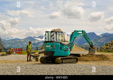 Wartung Arbeiter bewegte Masse mit einem Mini Bagger im Pavillon Seilbahn von Skyway Monte Bianco im Sommer, Courmayeur, Aostatal, Italien Stockfoto