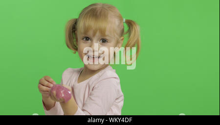 Kind Spaß machen ping Schleim. Kid spielen mit Hand gemacht Spielzeug Schleim. Lustig kind Mädchen. Entspannung und Zufriedenheit. Seltsamerweise zufriedenstellend rosa Schleim für puren Spaß und Stress Relief. Green Screen. Chroma Key Stockfoto