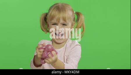 Kind Spaß machen ping Schleim. Kid spielen mit Hand gemacht Spielzeug Schleim. Lustig kind Mädchen. Entspannung und Zufriedenheit. Seltsamerweise zufriedenstellend rosa Schleim für puren Spaß und Stress Relief. Green Screen. Chroma Key Stockfoto