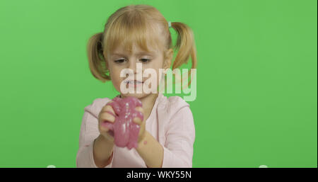 Kind Spaß machen ping Schleim. Kid spielen mit Hand gemacht Spielzeug Schleim. Lustig kind Mädchen. Entspannung und Zufriedenheit. Seltsamerweise zufriedenstellend rosa Schleim für puren Spaß und Stress Relief. Green Screen. Chroma Key Stockfoto