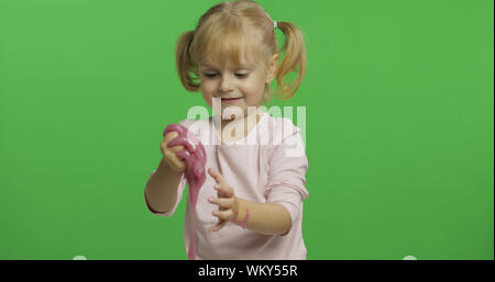 Kind Spaß machen ping Schleim. Kid spielen mit Hand gemacht Spielzeug Schleim. Lustig kind Mädchen. Entspannung und Zufriedenheit. Seltsamerweise zufriedenstellend rosa Schleim für puren Spaß und Stress Relief. Green Screen. Chroma Key Stockfoto