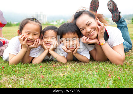 Muttertag. asiatische Mutter und ihre Kinder auf der grünen Wiese Stockfoto