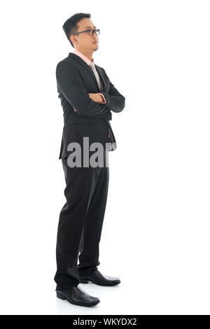 Volle Länge zuversichtlich südostasiatischen Business Mann überquerte Arme wegsehen stehen isoliert auf weißem Hintergrund. Stockfoto