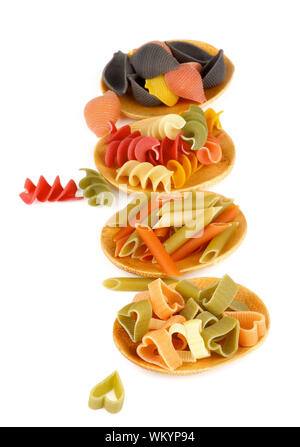 Die Anordnung der verschiedenen Rohstoffe italienische Pasta in kleinen hölzernen Untertassen isoliert auf weißem Hintergrund. Fokus auf den Vordergrund Stockfoto