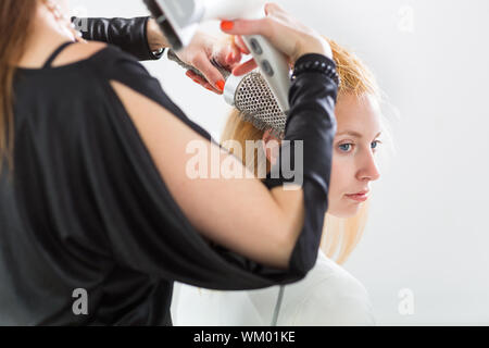 Friseur/Frisur Künstler arbeiten an eine junge Frau an den Haaren, indem es Form und Volumen Stockfoto