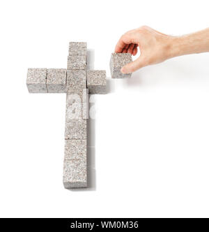 Menschen bauen ein christliches Kreuz machte der kleine Blöcke von Granitfelsen. Stockfoto