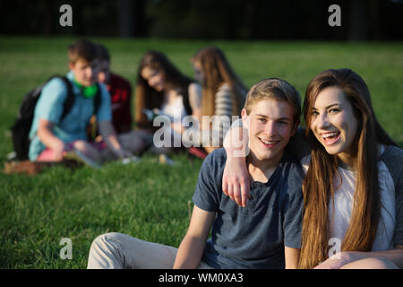 Happy Teen Freundin und Freund sitzen im Freien Stockfoto
