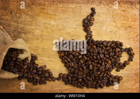 Bild einer Tasse Kaffee aus Bohnen auf dem Brett Stockfoto