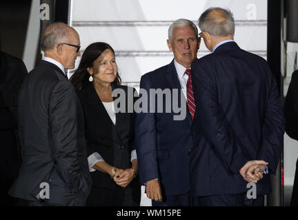 US-Vizepräsident Mike Pence und die zweite Frau Karen Pence sind durch Botschafter der Vereinigten Staaten in das Vereinigte Königreich Robert "Woody" Johnson (links) und Sonderbeauftragten der Außenminister David Pearey (rechts), wie sie ankommen am Flughafen Stansted für den Start eines offiziellen Besuchs in Großbritannien begrüßt. Stockfoto