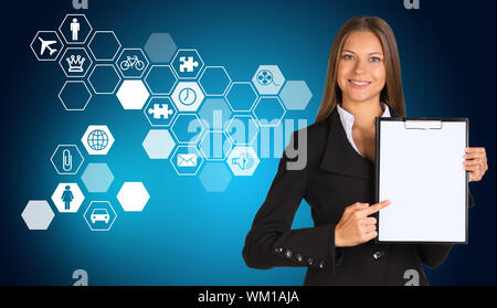 Schöne Geschäftsfrau, die in der Klage holding Papierhalter. Sechsecke mit Symbolen im Hintergrund Stockfoto