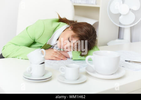 Büroangestellte ist auf Arbeit trotz betrunken durch Kaffee eingeschlafen Stockfoto