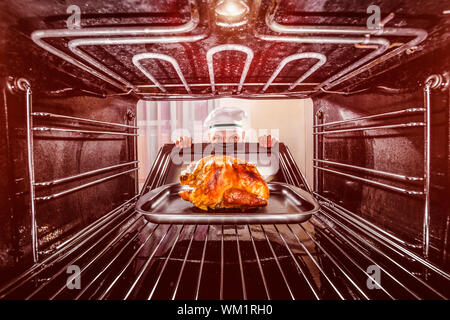 Chefkoch gebratenes Huhn in den Ofen, Blick aus dem Inneren des Ofens. Kochen in den Ofen. Stockfoto