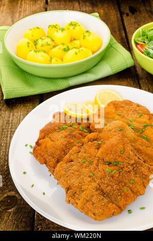 Deutsche Schnitzel mit Kartoffeln, Zwiebeln und Zitrone Stockfoto