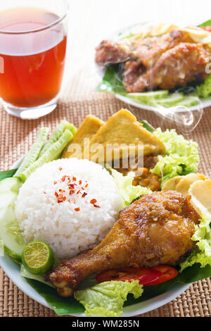 Beliebte indonesischen Spezialitäten Nasi Ayam Penyet, Indonesisch gebraten Huhn mit Reis. Frisch heiß mit Dampf Rauch. Stockfoto