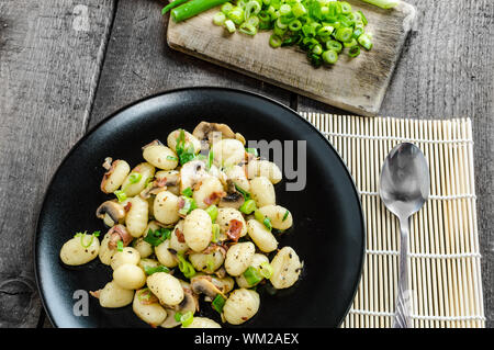 Gnocchi-Nudeln mit Schinken, Frühlingszwiebeln und Wein Stockfoto