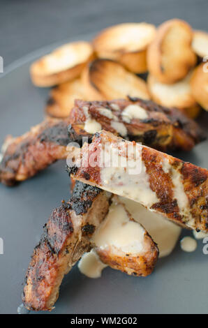 Spareribs vom Grill mit Dip, geröstetes Baguette Stockfoto