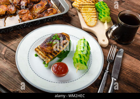 Klebrige Huhn mit pikanter Sauce, geröstete Panini mit grobkörnigem Salz und Olivenöl sowie Gurke kebab Stockfoto