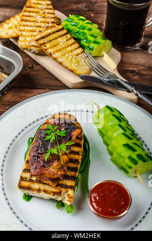 Klebrige Huhn mit pikanter Sauce, geröstete Panini mit grobkörnigem Salz und Olivenöl sowie Gurke kebab Stockfoto