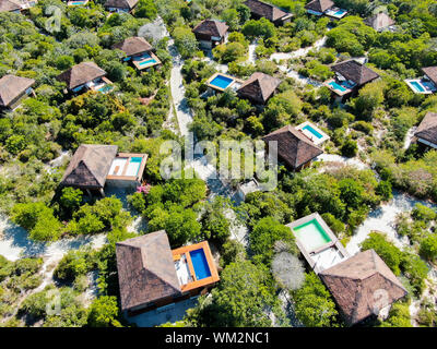 Luftaufnahme von Luxus Villa mit Swimming Pool in einem tropischen Wald. Private Tropical Villa mit Pool inmitten tropischer Garten mit Palmen Stockfoto