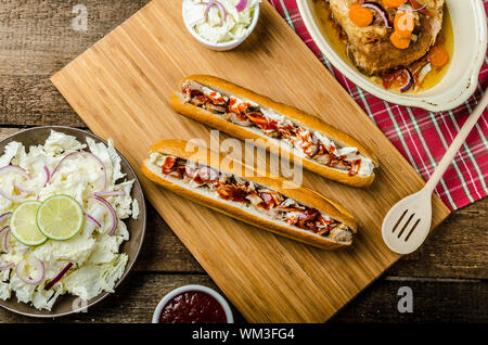 Schweinesandwich, lange gebackenes Schweinefleisch, in frischem Baguette mit frischem Salat und heiße Sause gezogen gezogen Stockfoto