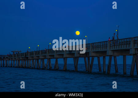 Vollmond über die Dania Beach Pier in Florida als Fischer Hoffnung für einen Bissen und Touristen schlendern, um die Pier. Stockfoto