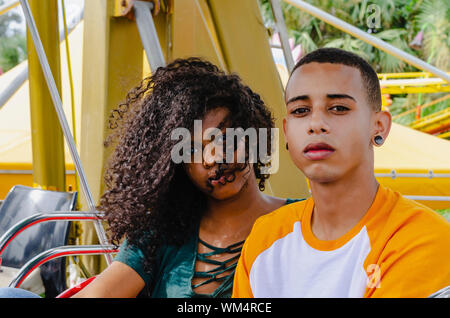 Jungen Latino Paar sitzt auf einem Riesenrad auf Kamera suchen Stockfoto