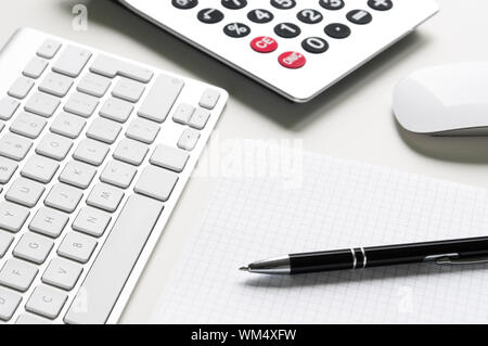 Schreibtisch mit Computer-Tastatur, Rechner und Ball-point Stockfoto