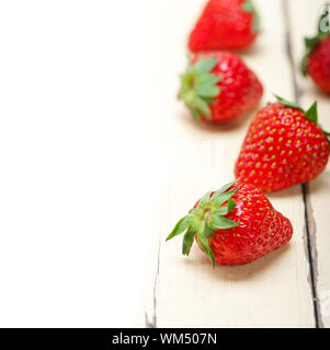 frische Bio Erdbeeren auf weißem Holz Stockfoto