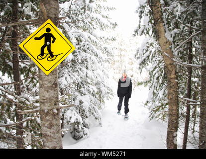 Schneeschuhe. Junge Frau Schneeschuhwandern im Kiefernwald in der Nähe der Baie Saint-Paul, Quebec, Kanada. Stockfoto