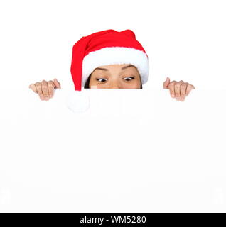 Weihnachten Frau mit unterzeichnen. Sehr schöne Mischlinge asiatischen/Kaukasisch Frau mit Reklametafeln Blick nach unten am Schild überrascht. Auf Rückseite weiß, isoliert Stockfoto