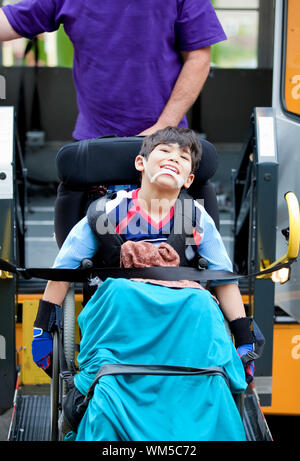 Gerne sieben Jahre alten Jungen auf Handikap School Bus Lift transportiert werden deaktiviert Stockfoto