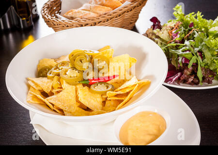 Nachos mit Käsesoße und Paprika pepperoni Stockfoto