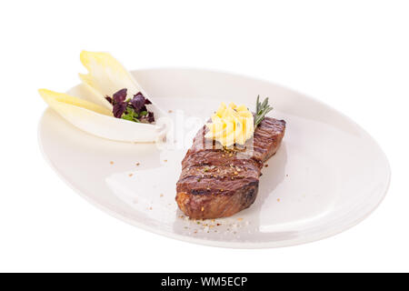 Lecker gegrilltes Rindersteak mit einem gezwirbelten Stück Butter und ein Zweig frischer Rosmarin garniert und serviert auf einem weißen Teller, Nahaufnahme Stockfoto