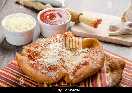 Traditioneller Karneval Fast-Food-Spezialität, frittierter Hefeteig mit Käse, Ketchup und Knoblauch Stockfoto