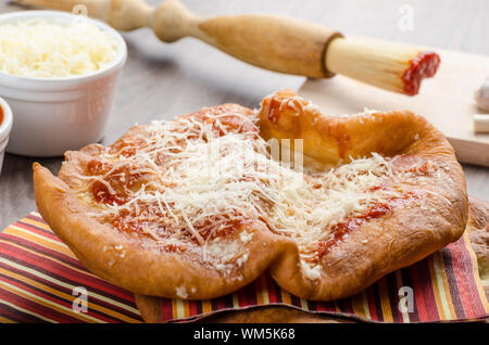 Traditioneller Karneval Fast-Food-Spezialität, frittierter Hefeteig mit Käse, Ketchup und Knoblauch Stockfoto