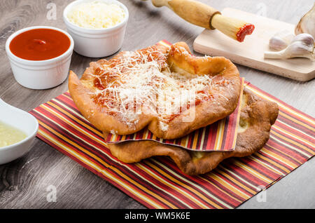 Traditioneller Karneval Fast-Food-Spezialität, frittierter Hefeteig mit Käse, Ketchup und Knoblauch Stockfoto