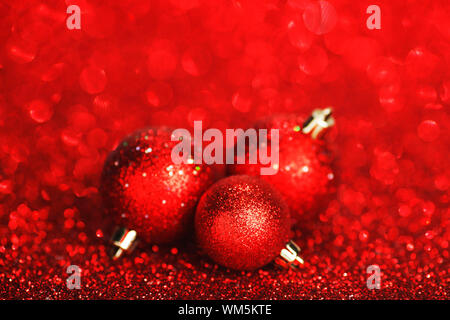 Rote Weihnachtskugeln über glänzend Glitzer Hintergrund Stockfoto