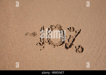 10 Prozent Rabatt in Erde Text geschrieben am braunen Sandboden Ebbe Strand Meeresküste in Spanien Europa Stockfoto