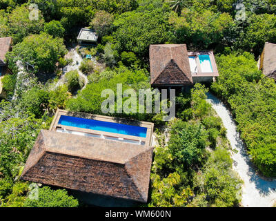 Luftaufnahme von Luxus Villa mit Swimming Pool in einem tropischen Wald. Private Tropical Villa mit Pool inmitten tropischer Garten mit Palmen Stockfoto