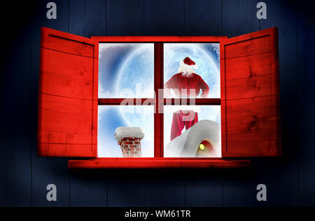 Santa Delivery stellt Dorf gegen Fenster in Holz- Zimmer Stockfoto