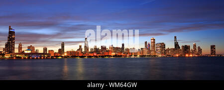 Panoramablick auf die Skyline von Chicago in der Dämmerung mit dem Michigan See im Vordergrund, IL, USA Stockfoto