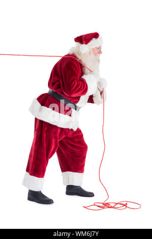 Santa zieht etwas mit einem Seil auf weißem Hintergrund Stockfoto